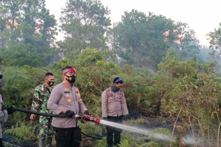 Kapolres Kepulauan Meranti AKBP Eko Wimpiyanto Hardjito bersama anggotanya dan prajurit TNI memadamkan titik api karhutla disejumlah lokasi di Kabupaten Kepulauan Meranti, Riau, Sabtu (27/2/2021).