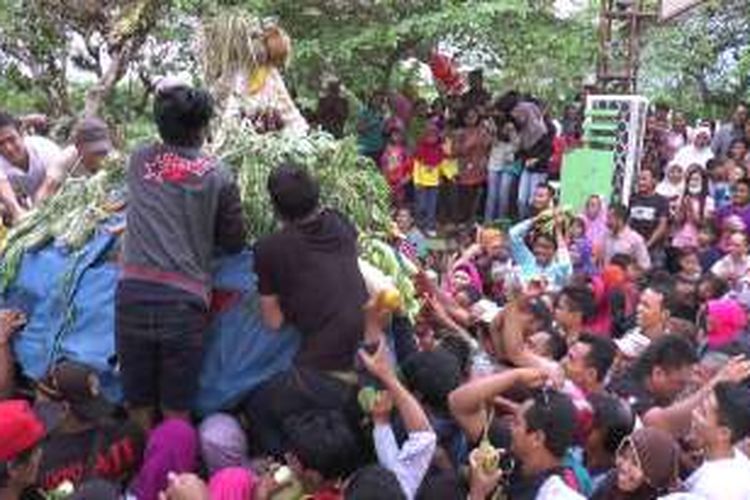 Warga berebut hasil bumi yang dipasang pada gunungan yang diarak dalam tradisi Syawalan di Boja, Kendal, Jawa Tengah, Selasa (17/7/2016).