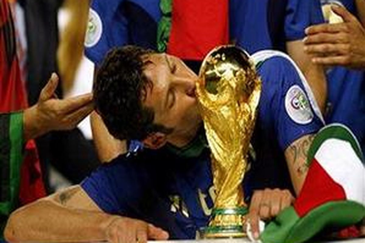 Marco Materazzi mencium trofi Piala Dunia yang diraih tahun 2006.