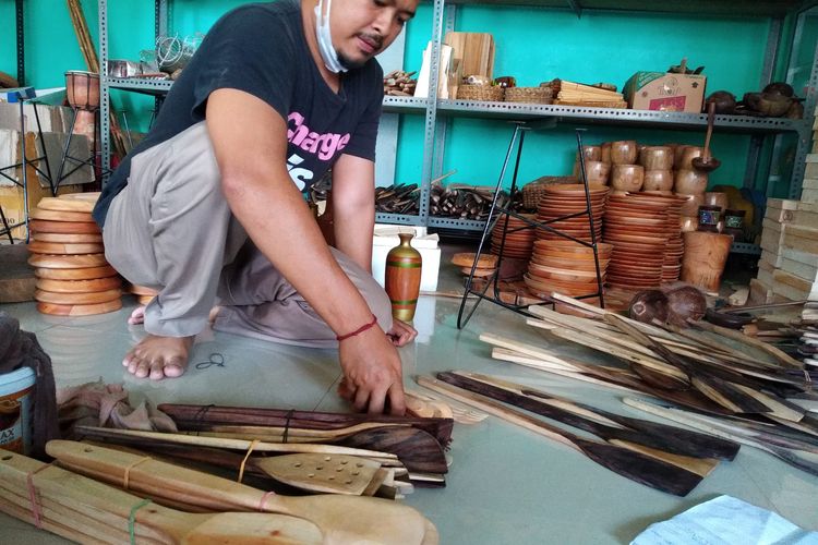 Seorang pekerja merapikan produk perabot dapur berbahan kayu di sebuah showroom milik perajin Susilowati di Kelurahan Sentul, Kota Blitar, Jumat (19/2/2021). Susilowati beralih ke produk perabot dapur setelah pasar kendang jembe tertutup akibat pandemi Covid-19. 
