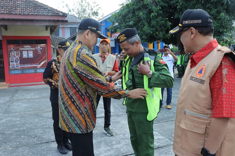 Wakil Bupati Wonogiri, Setyo Sukarno memakaian rompi pada salah satu anggota satlinmas usai memimpin apel Satlinmas desa/kelurahan di Kecamatan Wuryanto, Kabupaten Wonogiri, Jawa Tengah, Kamis (8/8/2024).