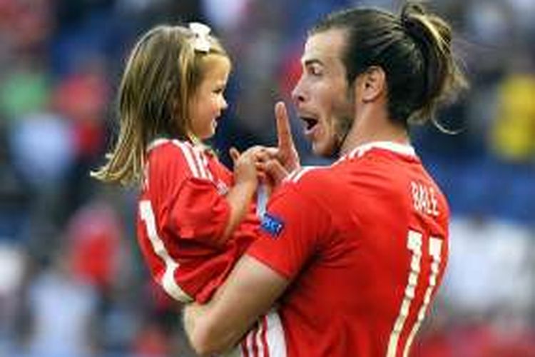 Pemain Wales, Gareth Bale, menggendong anak perempuannya, Alba Violet, usai laga kontra Irlandia Utara di Paris, pada 25 Juni 2016.