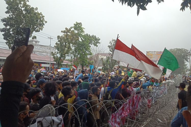 Massa yang menolak UU Cipta Karya bertahan di depan DPRD Sumbar kendati hujan deras, Rabu (7/10/2020)