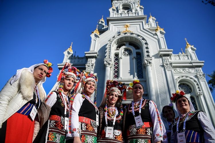 Perempuan mengenakan kostum tradisional Bulgaria berpose di depan Gereja St Stephen Bulgaria, yang juga dikenal sebagai Gereja Besi, setelah peresmian pembukaan kembali, di Istanbul, Minggu (7/1/2018). (AFP/Ozan Kose)