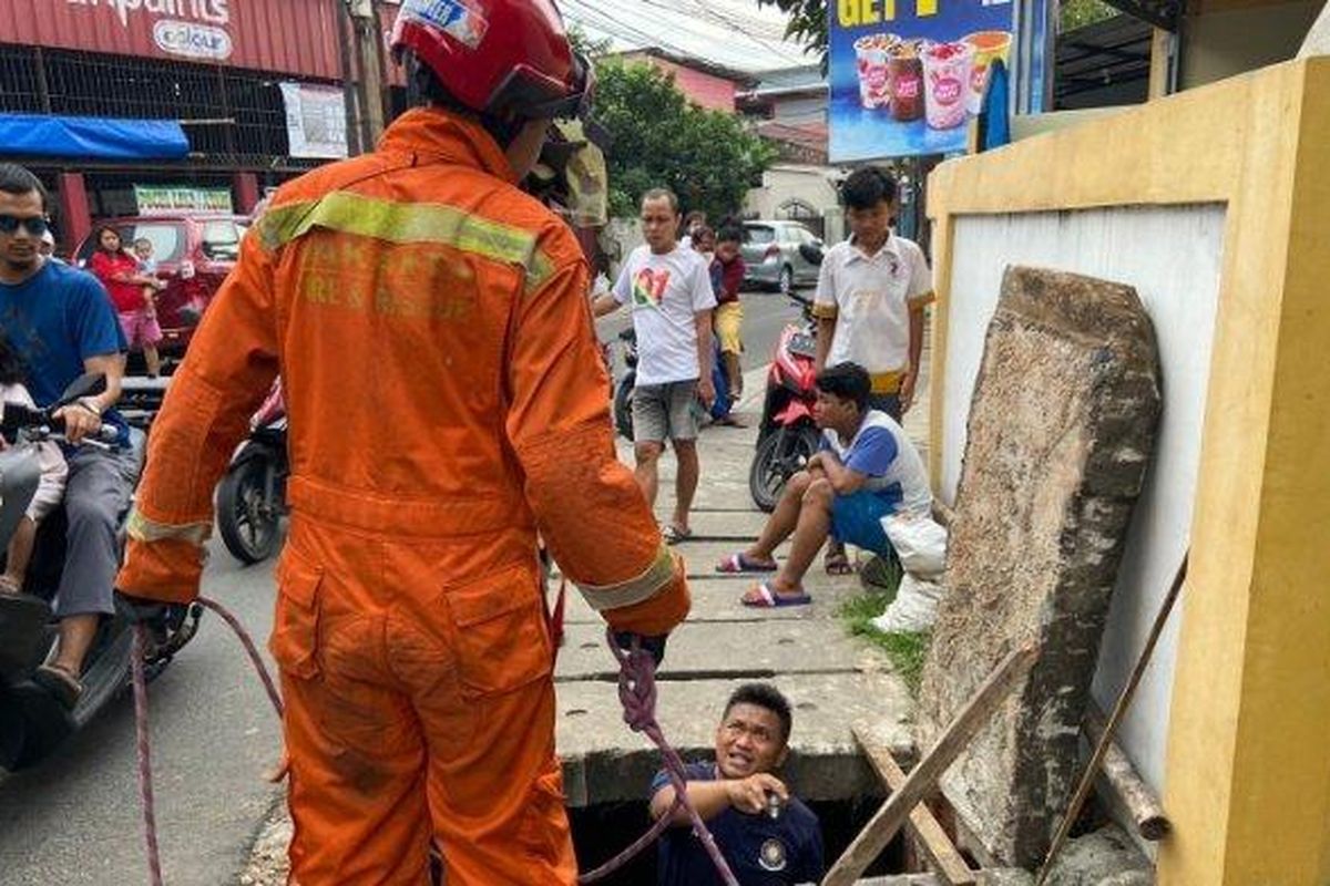 Personel Damkar Jakarta Timur saat proses pencarian maling yang masuk ke gorong-gorong di Jalan Gongseng Raya, Pasar Rebo, Minggu (22/5/2022) 