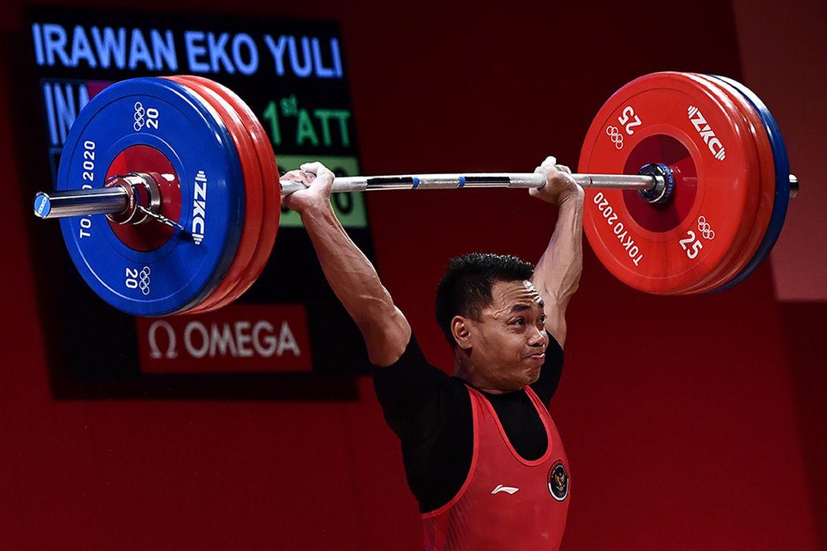 Lifter Indonesia Eko Yuli Irawan melakukan angkatan clean and jerk dalam kelas 61 kg putra Grup A Olimpiade Tokyo 2020 di Tokyo International Forum, Tokyo, Jepang, Minggu (25/7/2021). Eko Yuli berhasil mempersembahkan medali perak dengan total angkatan 302 kg.
