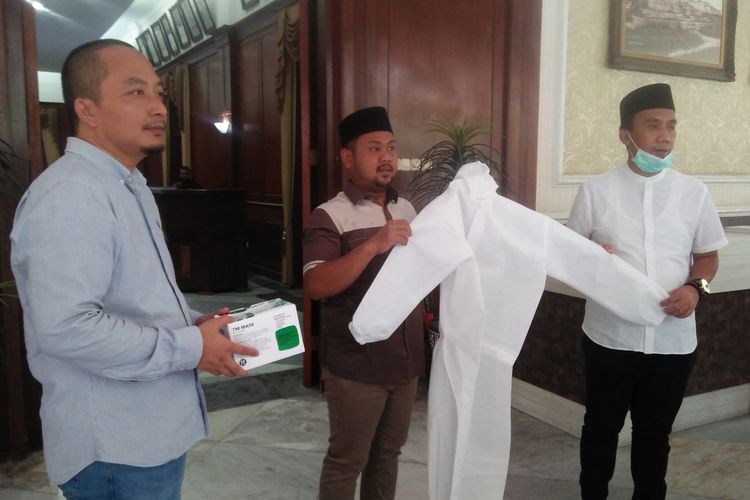 Saifudin Ghozali (kanan), saat mewakili penerimaan bantuan APD dan masker untuk tim medis puskesmas dari anggota DPRD Gresik, Rabu (1/4/2020).