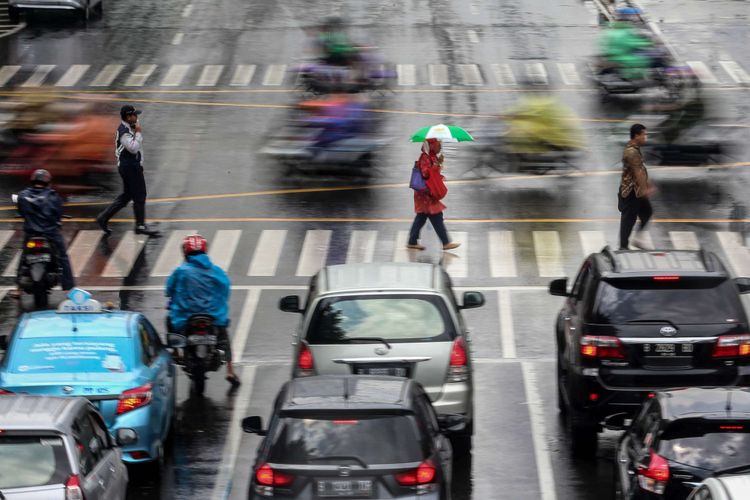 Pengguna kendaraan menembus hujan di Jl. M.H. Thamrin, Jakarta, Jumat (22/2/2019). Badan Meteorologi, Klimatologi, dan Geofisika (BMKG) memprediksi hujan akan mengguyur wilayah Jabodetabek pada Jumat (22/2/2019) siang.