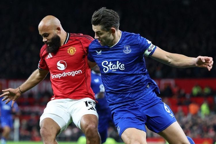 Bryan Mbeumo (kiri) dibayangi James Tarkowski (kanan) dalam pertandingan sepak bola Liga Inggris antara Manchester United vs Everton di Old Trafford di Manchester, barat laut Inggris, pada 24 November 2025. (Foto oleh Darren Staples / AFP) / DIBATASI UNTUK PENGGUNAAN EDITORIAL. Tidak ada penggunaan dengan audio, video, data, daftar perlengkapan, logo klub/liga, atau layanan 'langsung' yang tidak sah. Penggunaan dalam pertandingan online dibatasi hingga 120 gambar. 40 gambar tambahan dapat digunakan dalam waktu tambahan. Tidak ada emulasi video. Penggunaan media sosial yang cocok dibatasi hingga 120 gambar. 40 gambar tambahan dapat digunakan dalam waktu tambahan. Tidak digunakan dalam publikasi taruhan, permainan atau publikasi klub/liga/pemain tunggal. /