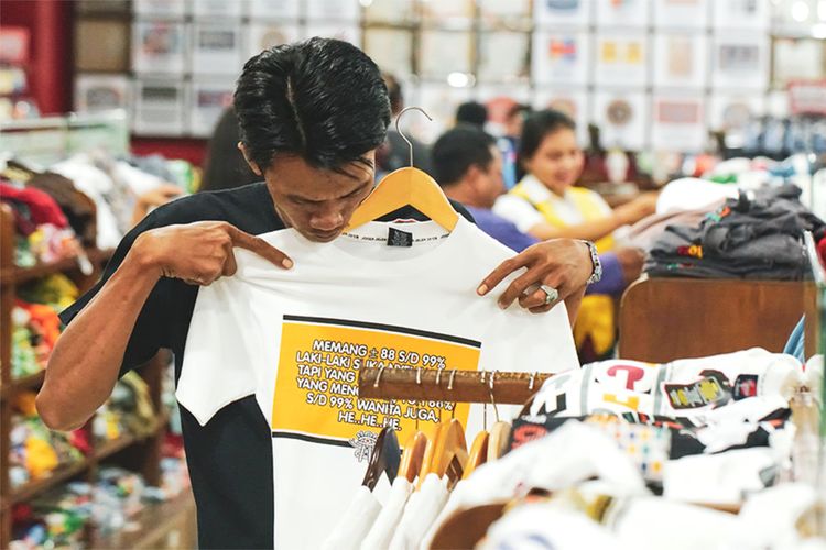 Salah satu konsumen sedang melihat baju-baju dari Joger Bali (jogerjelek.com)
