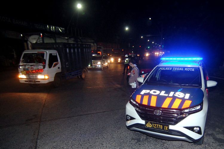 Petugas kepolisian mengatur lalu lintas saat penutupan jalur Pantura dan dialihkan ke jalr lingkar utara (Jalingkut), Tegal, Jawa Tengah, Senin (22/3/2020) malam. Pemerintah Kota Tegal dan Polres Tegal hingga 14 hari mendatang melakukan lockdown lokal dengan menutup jalur Pantura yang melintasi Kota Tegal, akses masuk Alun-alun Tegal dan mematikan sebagian lampu jalan protokol guna pembatasan kendaraan yang akan masuk ke Kota Tegal dan mencegah adanya kerumunan massa di jalan untuk mencegah penyebaran COVID-19. ANTARA FOTO/Oky Lukmansyah/aww.