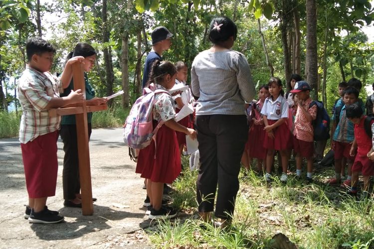 Pelajar SD Kanisius Kenalan menyimak cerita soal 14 perhentian jalan salib di Kulonprogi, DI Yogyakarta, Selasa (26/3/2024).