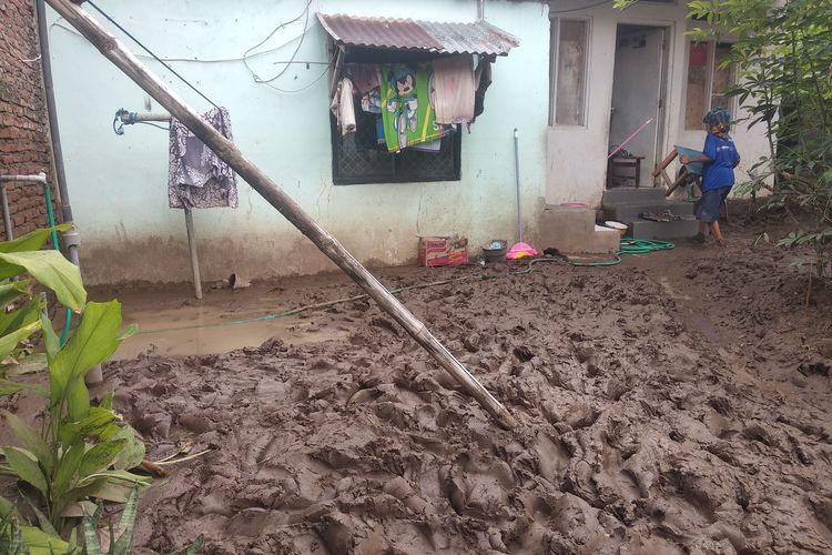 Korban banjir di Kota Bima saat membersihkan perkakas rumah tangga yang teredam lumpur, Senin (12/2/2024).