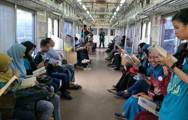 Relawan pegiat literasi mengampanyekan aksi membaca buku di dalam KRL dari Stasiun Jakarta Kota sampai Stasiun UI dalam rangka hari buku sedunia, Minggu (22/4/2018).