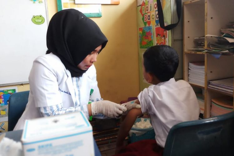 Salah seorang Dokter melakukan imunisasi Campak MR kepada salah seorang siswa SDN 02 Sekupang, Batam