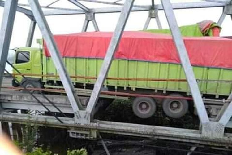 Jembatan Mesuji yang amblas akibat roda sebuah kendaraan truk besar penuh muatan terperosok di bagian tengah jembatan yang aspalnya lepas Minggu (16/6/2019)     