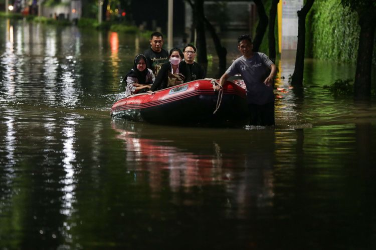 Warga melintasi banjir yang mengenang kawasan Kemang, Jakarta Selatan, Kamis (6/10/2022) malam. Hujan deras yang mengguyur wilayah Jakarta siang menyebabkan Jalan Kemang Raya, Jakarta Selatan, terendam banjir.