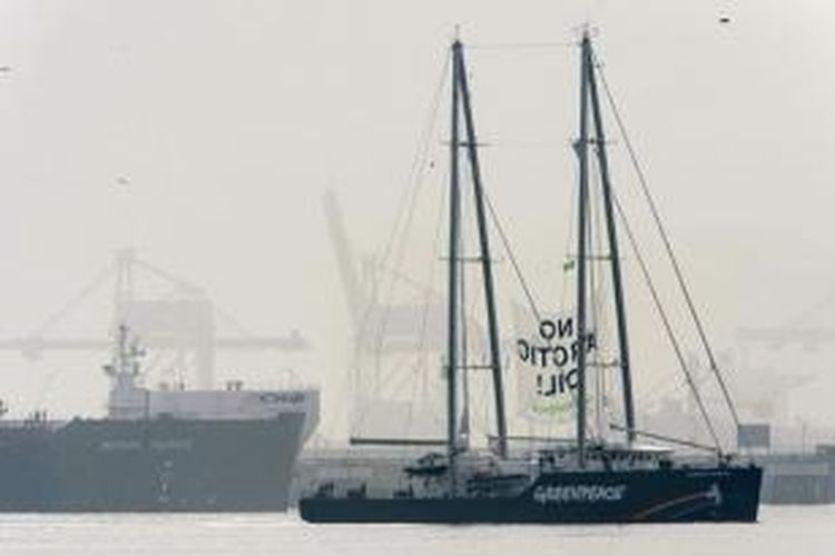 Kapal milik Greenpeace, Rainbow Warrior berlayar sambil membawa spanduk 