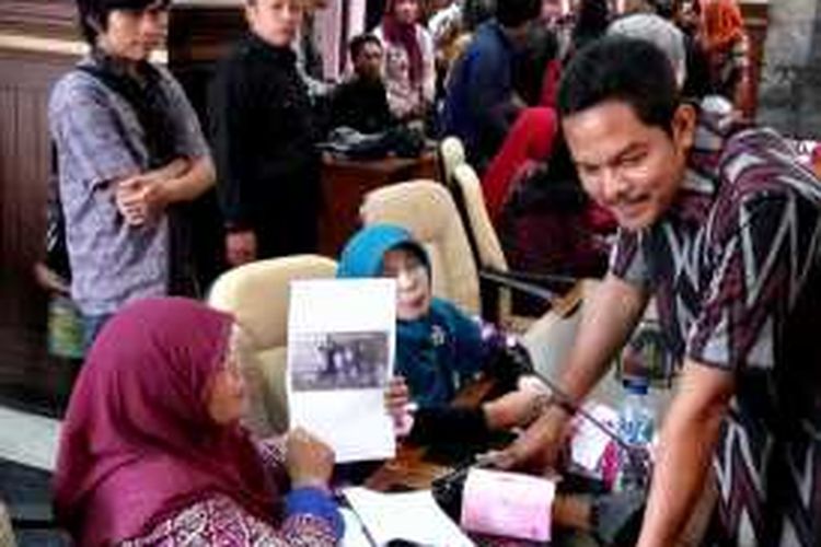 Istiana saat menunjukan foto Anak, menantu dan cucu nya yang hilang kepada Wakil Ketua DPRD DIY Arif Noor Hartanto