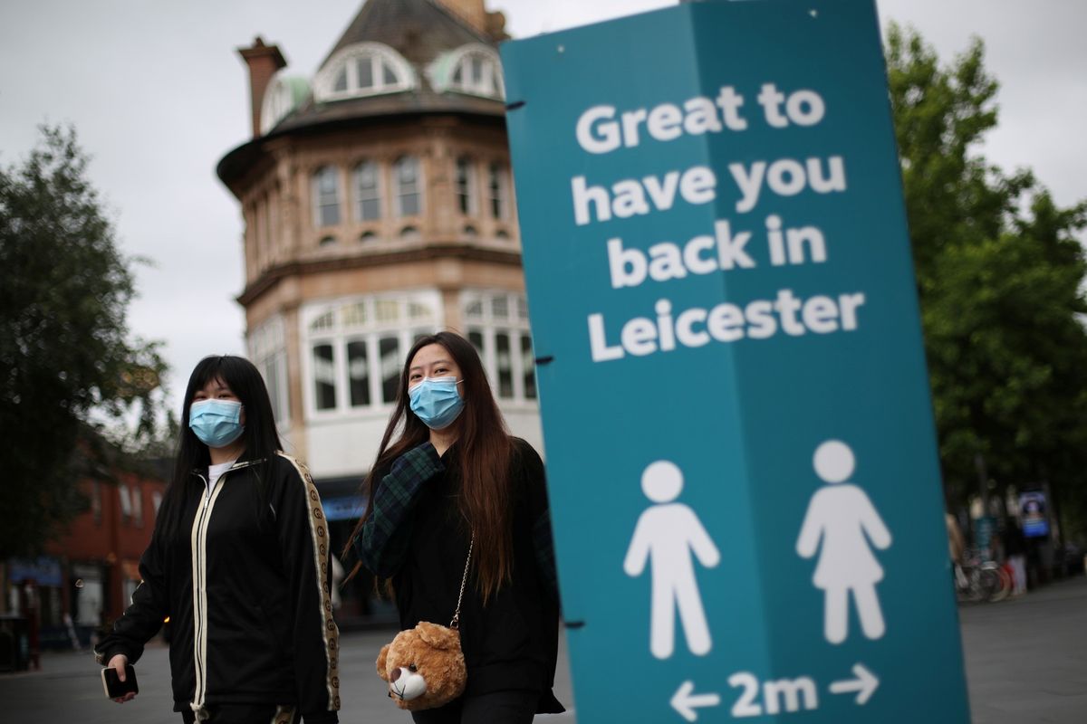 Warga memakai masker saat berjalan dan melewati marka, ditengah wabah penyakit virus corona (COVID-19), di Leicester, Inggris, Senin (29/6/2020). 