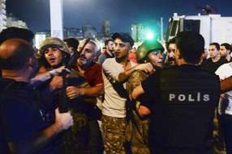 Tentara Turki yang ditangkap oleh warga sipil diserahkan ke polisi, di Taksim Square, Istanbul, Sabtu (16/7/2016) dini hari waktu setempat. Upaya kudeta terjadi pada Jumat malam setelah militer mengeluarkan pernyataan telah mengambil alih kekuasaan untuk mengembalikan aturan dan demokrasi di negeri itu.