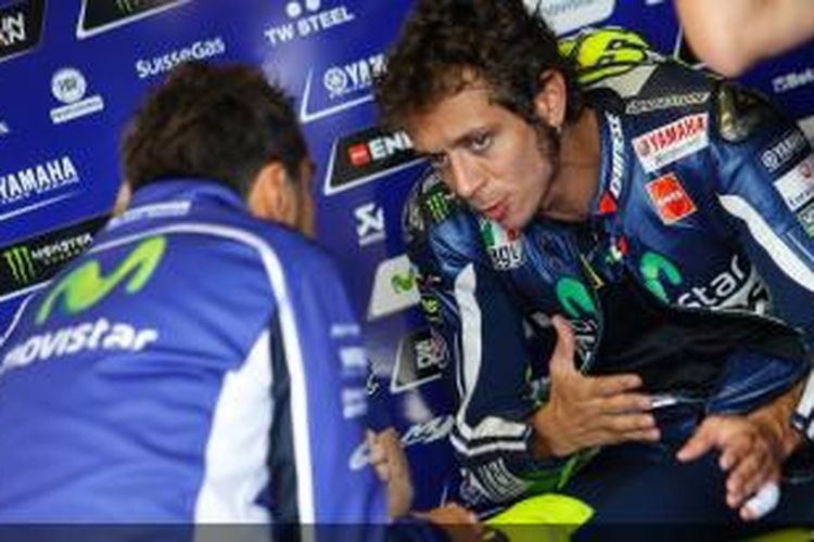 Pebalap Movistar Yamaha asal Italia, Valentino Rossi, berbicara dengan kru di paddock Sirkuit Brno, pada sesi kualifikasi GP Ceko, Sabtu (16/8/2014).