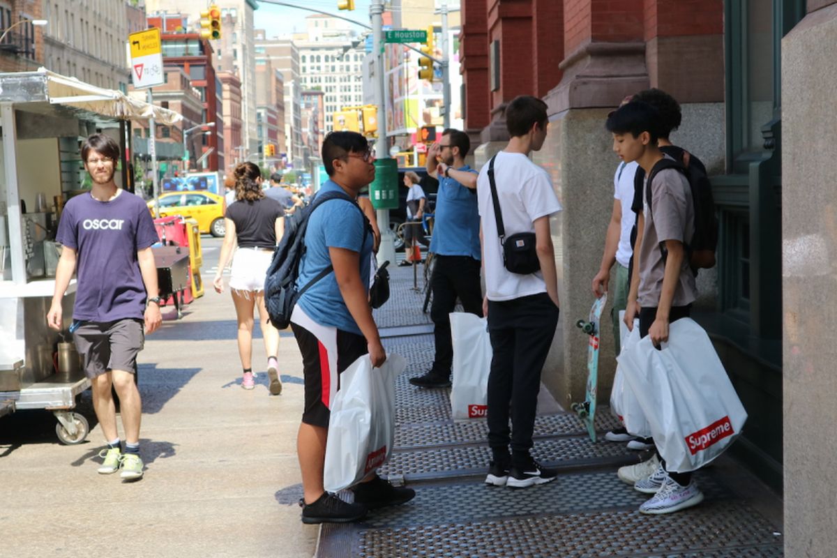 Rombongan milenial beristirahat setelah berjam-jam antre masuk toko skateboard Supreme di Lafayette St, NEw York.                         