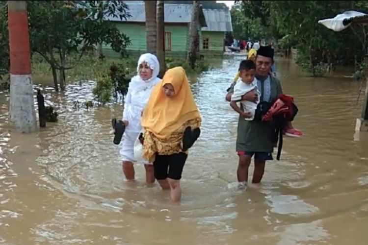 Warga korban banjir di Kota Kendari, Sulawesi Tenggara, harus melewati genangan banjir untuk menuju lokasi shalat Id, Rabu (5/6/2019).