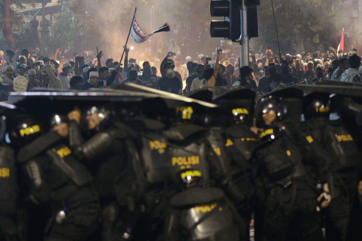 Polisi bertahan dari lemparan batu para demonstran yang ricuh di dekat gedung Bawaslu, Jalan MH Thamrin, Rabu (22/5/2019) malam.