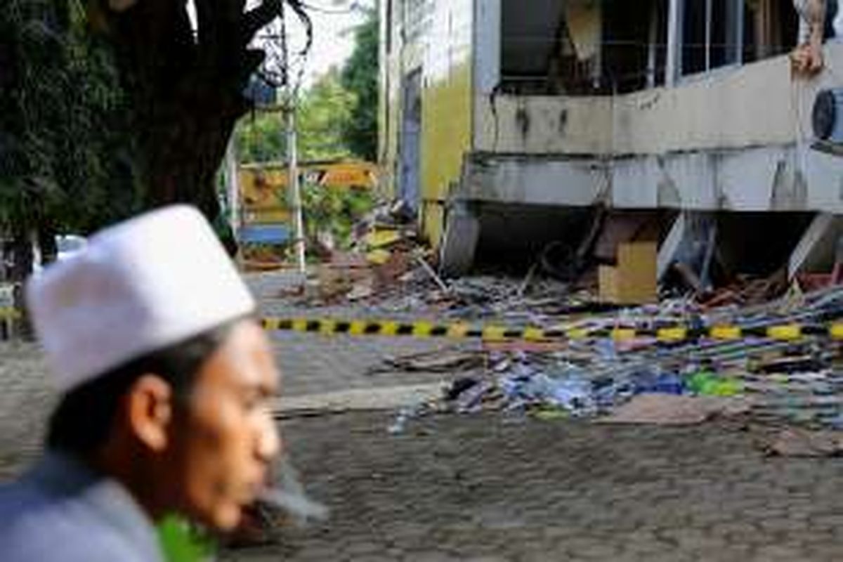 Warga melintas di samping bangunan pondok pesantren di bawah Lembaga Pendidikan Islam Ma'hadal Ulum Diniyah Islamiyah roboh akibat gempa di Samalanga, Kabupaten Bireun, Aceh, Sabtu (10/12/2016). Presiden joko Widodo berjanji untuk secepatnya dilakukan pembangunan kembali dan  akan ditangani oleh Kementerian Pekerjaan Umum dan Perumahan Rakyat.