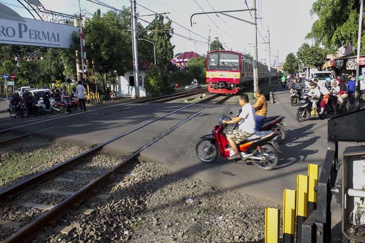 Pengendara melintas di perlintasan kereta api wilayah Bumi Bintaro Permai, Pondok Aren, Jakarta Selatan, Sabtu (22/2/2020). Tidak berfungsinya palang pintu di perlintasan kereta api sejak 2 tahun lalu mengancam keselamatan warga. 