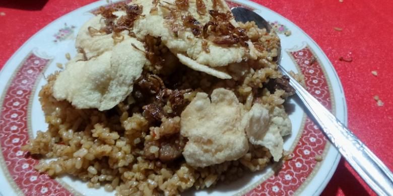 Seporsi Nasi Goreng Kebon Sirih dengan taburan bawang goreng dan daging kambing beserta kerupuk emping.(Kompas.com/Wahyu Adityo Prodjo)