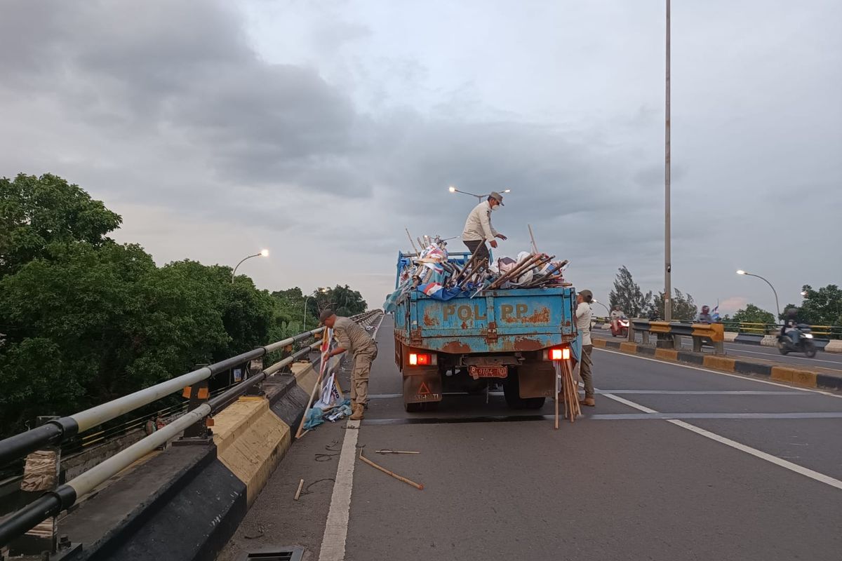 Penertiban alat peraga kampanye (APK) yang dilakukan oleh Panwaslu Kecamatan Ciracas bersama dengan Satpol PP di flyover Pasar Rebo, Ciracas, Jakarta Timur, Rabu (24/1/2024).