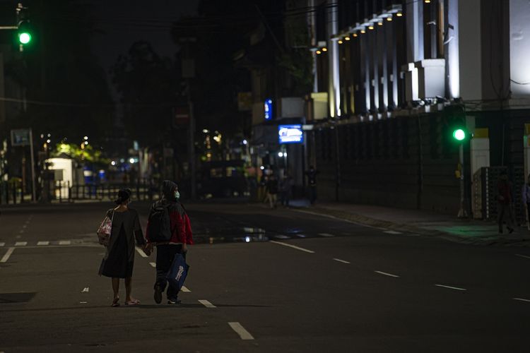 Warga berjalan melewati Jalan Pintu Besar Utara yang ditutup karena kebijakan Pemberlakuan Pembatasan Kegiatan Masyarakat (PPKM) di Kota Tua, Jakarta, Kamis (21/1/2021). Setelah diberlakukan mulai  tanggal 11 hingga 25 Januari 2021, pemerintah memperpanjang PPKM selama dua pekan dari 26 Januari hingga 8 Februari 2021 di Jawa-Bali untuk mencegah penyebaran virus corona. ANTARA FOTO/Aditya Pradana Putra/foc.