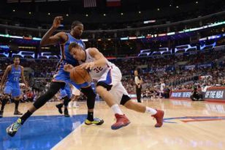 Pebasket Los Angeles Clippers, Blake Griffin (putih) mencoba menembus pertahanan pemain Oklahoma City Thunder, Kevin Durant (biru), saat kedua tim bertemu pada lanjutan kompetisi NBA di Staples Center, Rabu (13/11/2013).