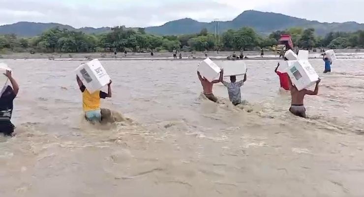 Warga NTT Terobos Banjir Sambil Memikul Puluhan Kotak Suara