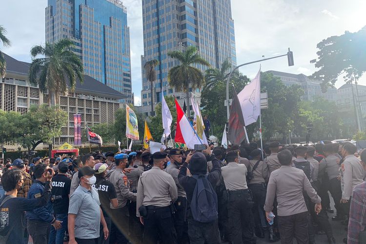 Peserta aksi unjuk rasa dari mahasiswa terlibat aksi saling dorong dengan petugas kepolisian setelah massa pengunjuk rasa berusaha memblokade persimpangan Jalan Medan Merdeka Barat dan Jalan Budi Kemuliaan, Jakarta Pusat, Jumat (30/9/2022).
