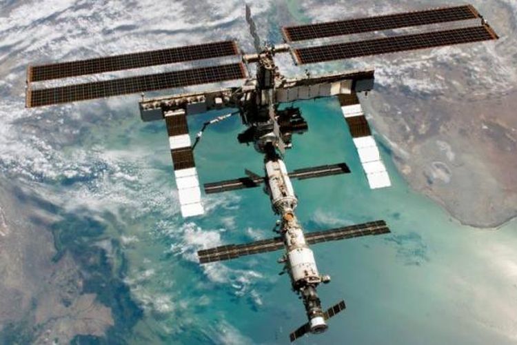Foto utuh Stasiun Luar Angkasa Internasional saat berada di orbit bumi di atas Laut Kaspia. Di dalam inilah para awak Ekpedisi 35 berada untuk melakukan penelitian luar angkasa.