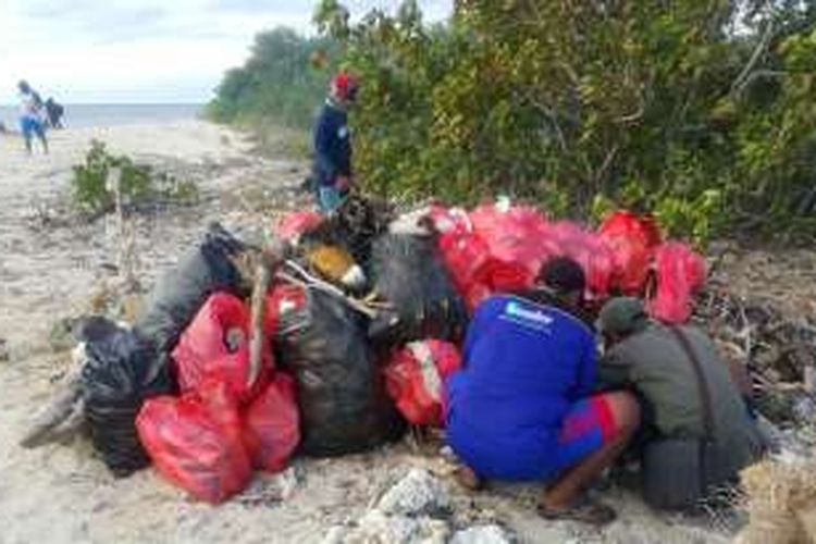 Nelayan dan relawan mengumpulan ratusan sampah di Pulau Tabuhan Banyuwangi Senin (18/7/2016)