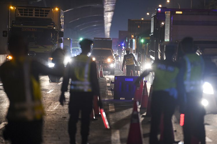 Petugas kepolisian mengarahkan kendaraan pribadi yang melintas di tol Jakarta-Cikampek untuk keluar melalui pintu tol Cikarang Barat 3, Jawa Barat, Kamis (21/5/2020). Pengalihan tersebut sebagai upaya penyekatan gelombang pemudik jelang perayaan Hari Raya Idul Fitri 1441 H dari arah Jakarta menuju Jawa Tengah.