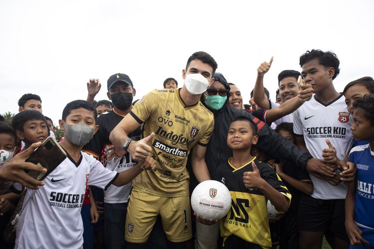 Pemain Bali United Nadeo Agrawinata foto bareng pemain ssh seusai membagikan bola dalam rangkaian kegiatan syukuran menjuarai Liga 1 2021-2022 di Pantai Purnama Gianyar, Senin (28/3/2022) siang.