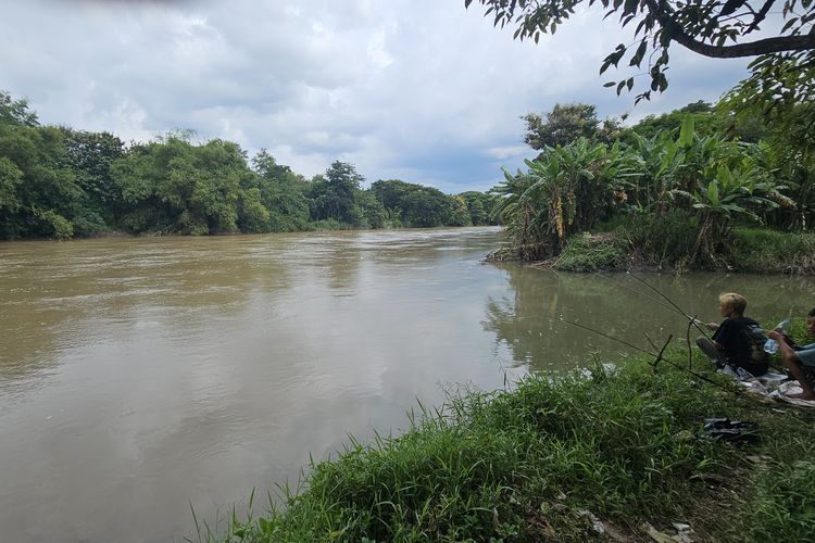 Anak-anak memancing di pertemuan Sungai Pusur dengan Bengawan Solo, Minggu (23/2/2025)