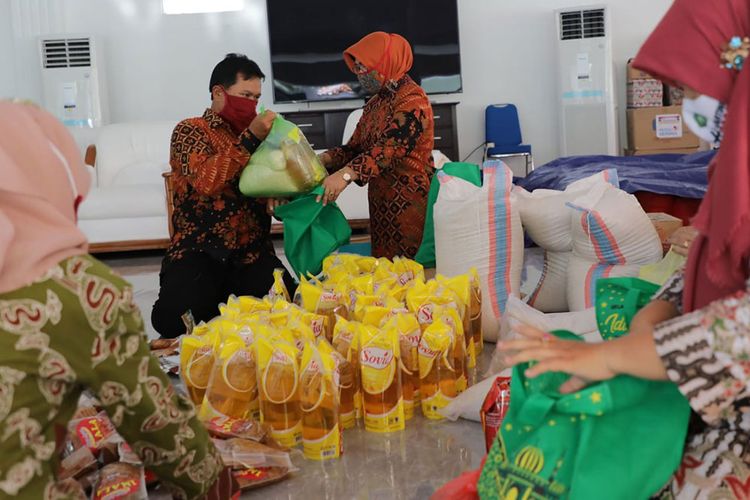 BANTU MENGEPAK-Wali Kota Madiun, Maidi bersama istrinya yang juga sebagai Ketua TP PKK Kota Madiun, Yuni Setyawati Maidi membantu proses pengepakan sembako untuk segera didistrubusikan bagi warga yang terdampak Covid-19. 