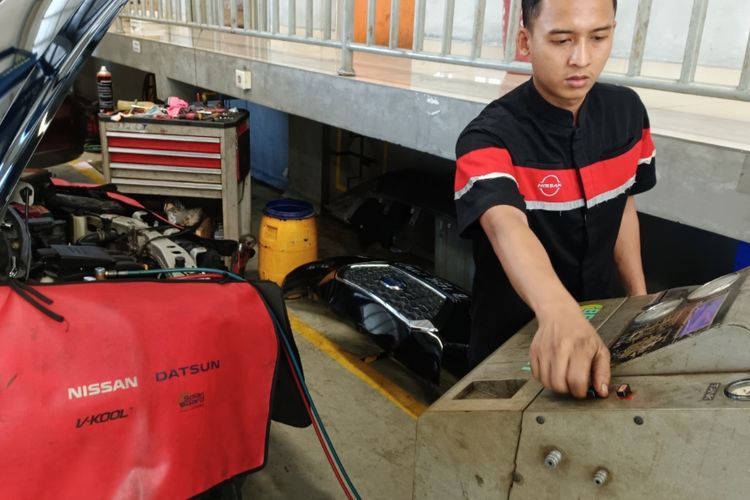 Mekanik bengkel resmi Nissan Setiabudi Semarang sedang melakukan perbaikan komponen AC mobil