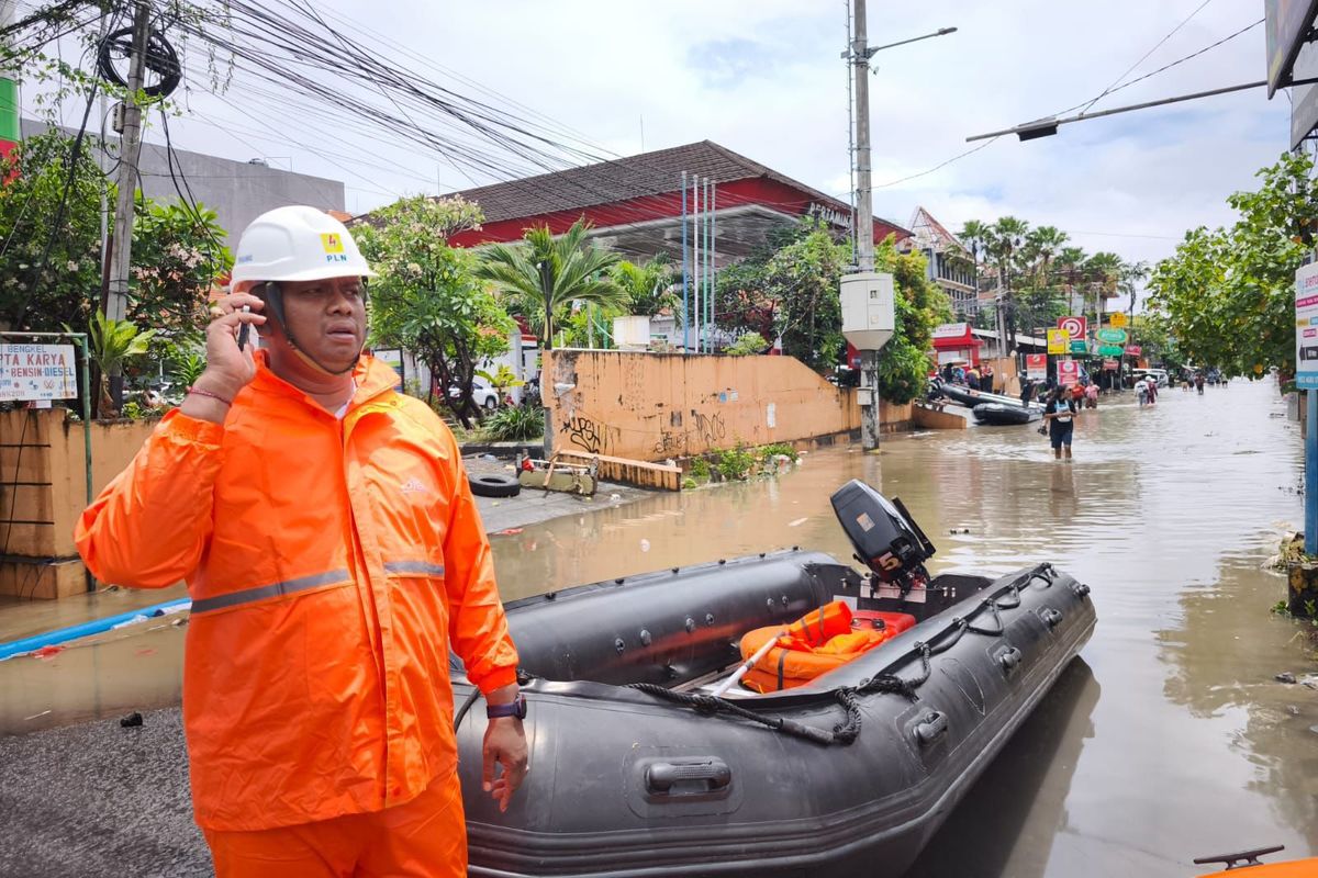 Petugas PLN memeriksa jaringan listrik yang terkendala akibat banjir.
