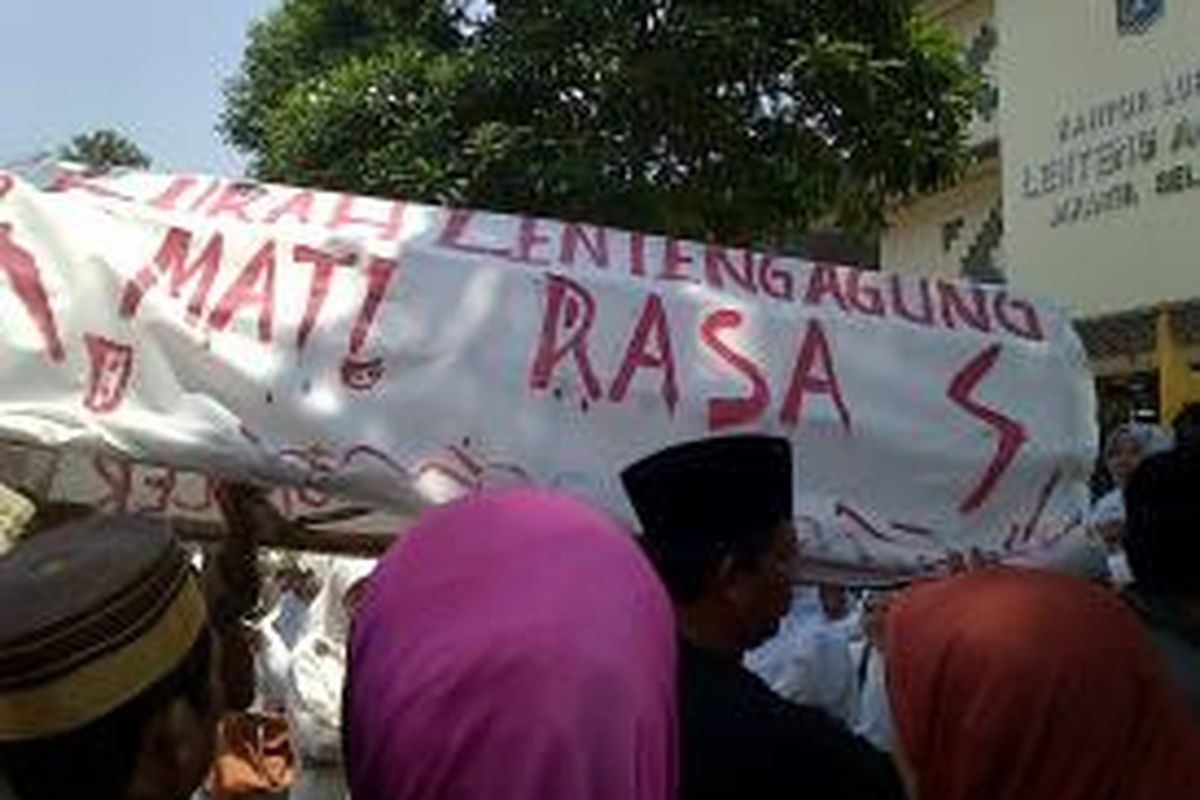 Para warga yang melakukan aksi damai di depan Kantor Lurah Lenteng Agung di akhir aksinya, menyerahkan keranda yang di bawa dalam aksi ke Kelurahan. Mereka memaksa Lurah Susan Jasmine Zulkifli untuk menerima keranda tersebut, namun akhirnya keranda di terima oleh Kapolsek Jagakarsa, Kompol Herawaty, Jakarta selatan, Rabu (25/9/2013)