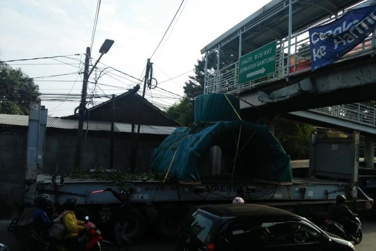 Sebuah truk trailer tersangkut di Jembatan Penyeberangan Orang (JPO) Jembatan Gantung, Jakarta Barat, Sabtu (8/9/2018) pagi. Hal itu semakin memperparah kondisi JPO yang sebelumnya juga telah rusak akibat dihantam truk pada 29 Juli lalu.