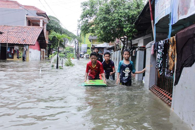Warga menyaksikan banjir yang terjadi di Jalan Nurul Hidayah, Kramat Jati, Jakarta Timur, Rabu (1/1/2020). Longsor dan Banjir disebabkan oleh intensitas curah hujan yang tinggi.