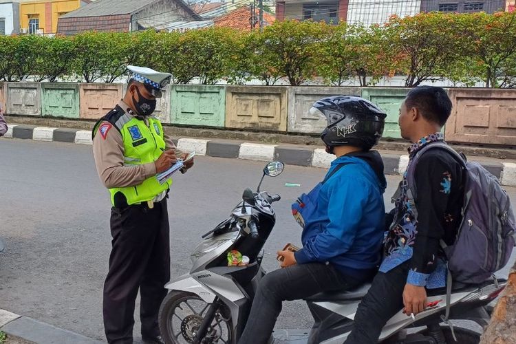 Sejumlah pemotor ditilang karena tak mengenakan helm saat melintas di depan Stasiun Pasar Minggu, Jakarta Selatan, Kamis (21/9/2023).