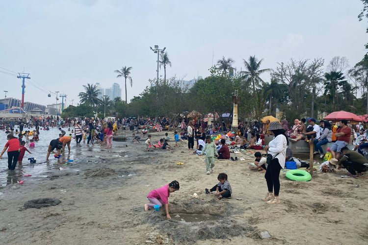 Sejumlah pengunjung Taman Impian Jaya Ancol tengah asyik bermain di Pantai Indah, Senin (25/12/2023).
